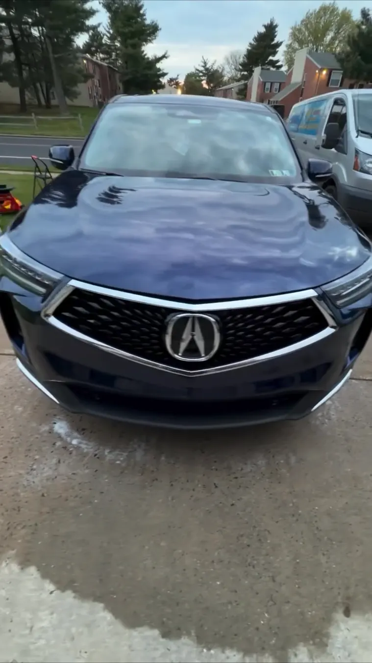 Front of a dark blue Acura after a wash