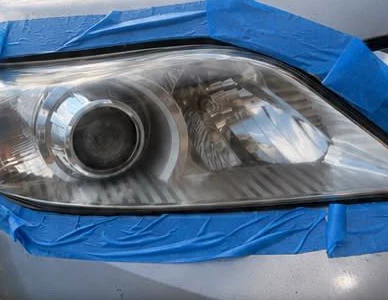 The process: the same headlight taped off for sanding and polishing